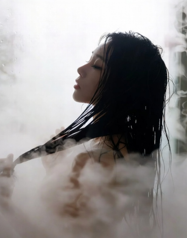 뿌연 수증기가 가득한 욕실 인테리어, 젖은 머리카락을 쓸어 넘기는 배우의 상반신 실루엣이 불투명한 유리문 너머로 비치고 있으며, 배우가 직접 들고 찍는 듯한 거친 앵글로 현장의 습도와 열기가 그대로 느껴지는 사진